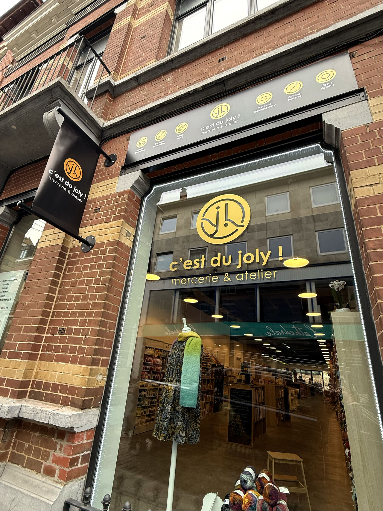 C'est du Joly - Mercerie - Atelier couture - Bruxelles - Logo - Identité visuelle - Graphisme - Branding - Periskop - Agence de communication - Studio graphique - Enseigne - Vitrine - Vitrophanie - Drapeau - Bâche